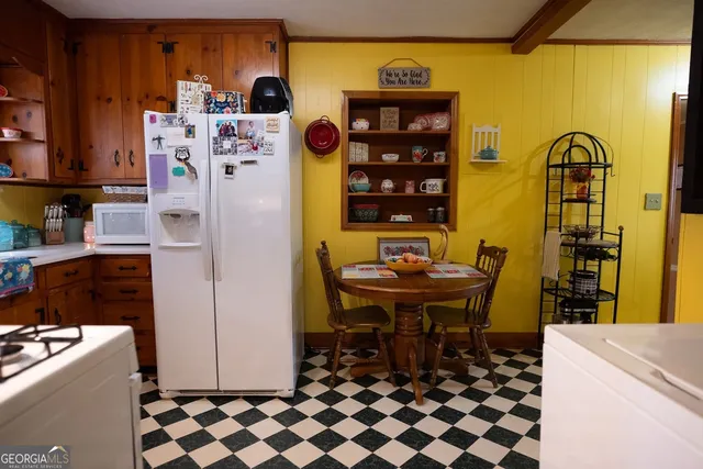 a kitchen with a appliances a sink and a dining table