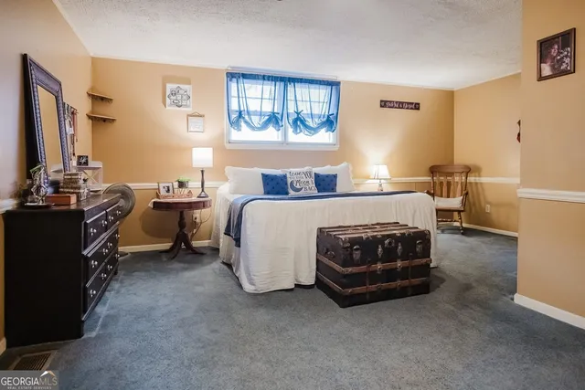 a bed sitting in a bedroom and a flat tv screen