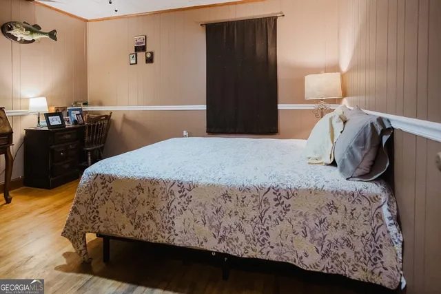 a bed sitting in a bedroom with wooden floor