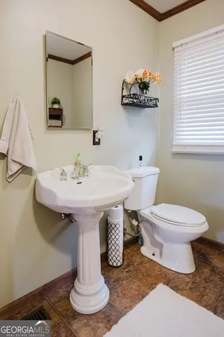 a bathroom with a sink toilet and a mirror