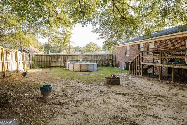 a view of a house with backyard and tree