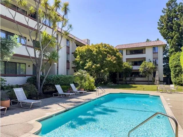 a view of a house with swimming pool and sitting area