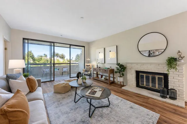 a living room with furniture a fireplace a rug and a large window