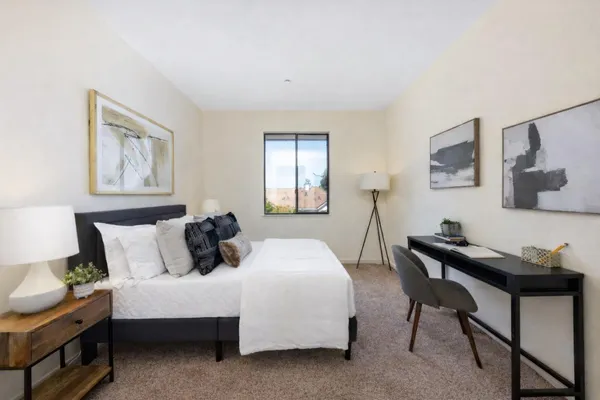 a bedroom with a bed a table and chair