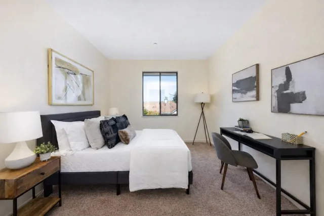 a bedroom with a bed a table and chair