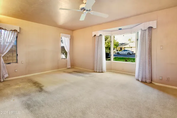 a view of a big room with wooden floor and windows