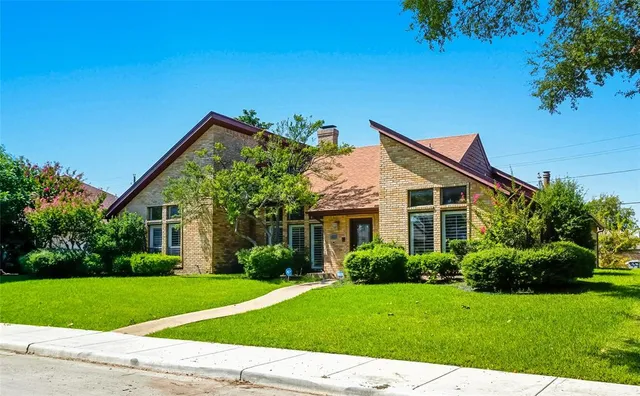 a view of a house with a yard and potted plants