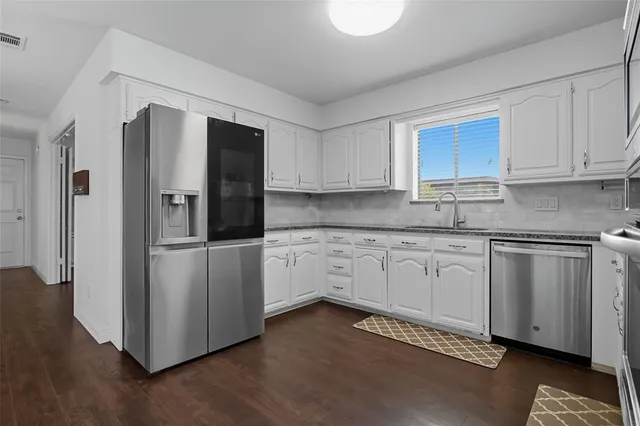 a kitchen with stainless steel appliances granite countertop a refrigerator sink and cabinets