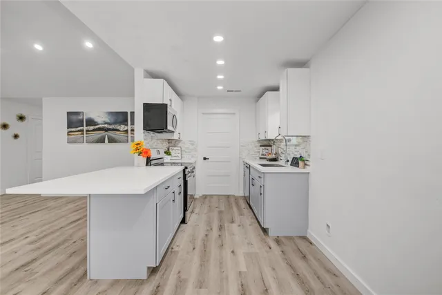 a kitchen with granite countertop a sink stove and cabinets