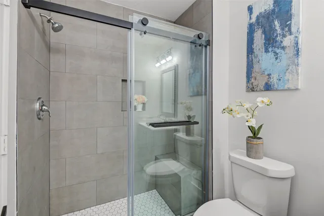 a bathroom with a toilet and a shower