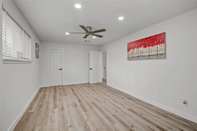 a view of room with wooden floor and ceiling fan