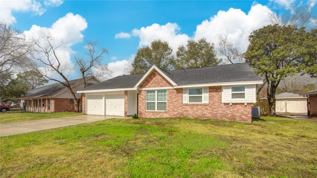 a front view of house with yard and trees around