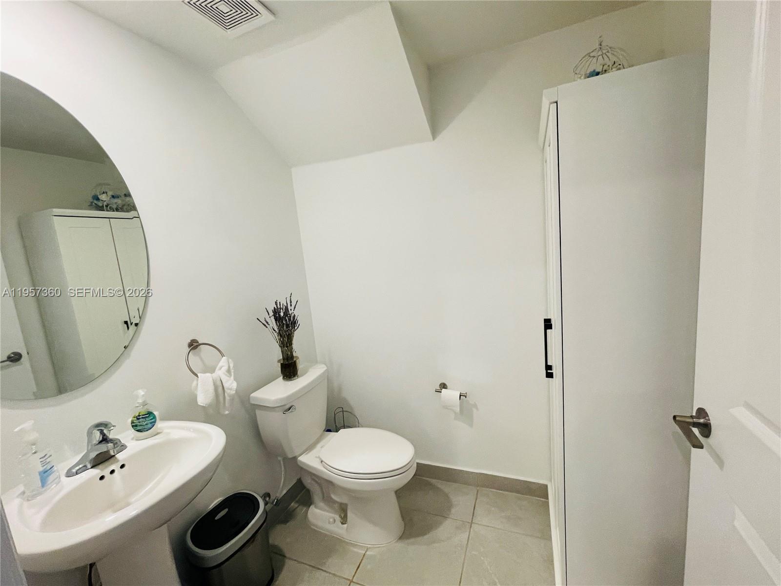 23153 Southwest 128th Place Miami, FL 33177 - Photo 8 of 22 a bathroom with a toilet a sink and mirror