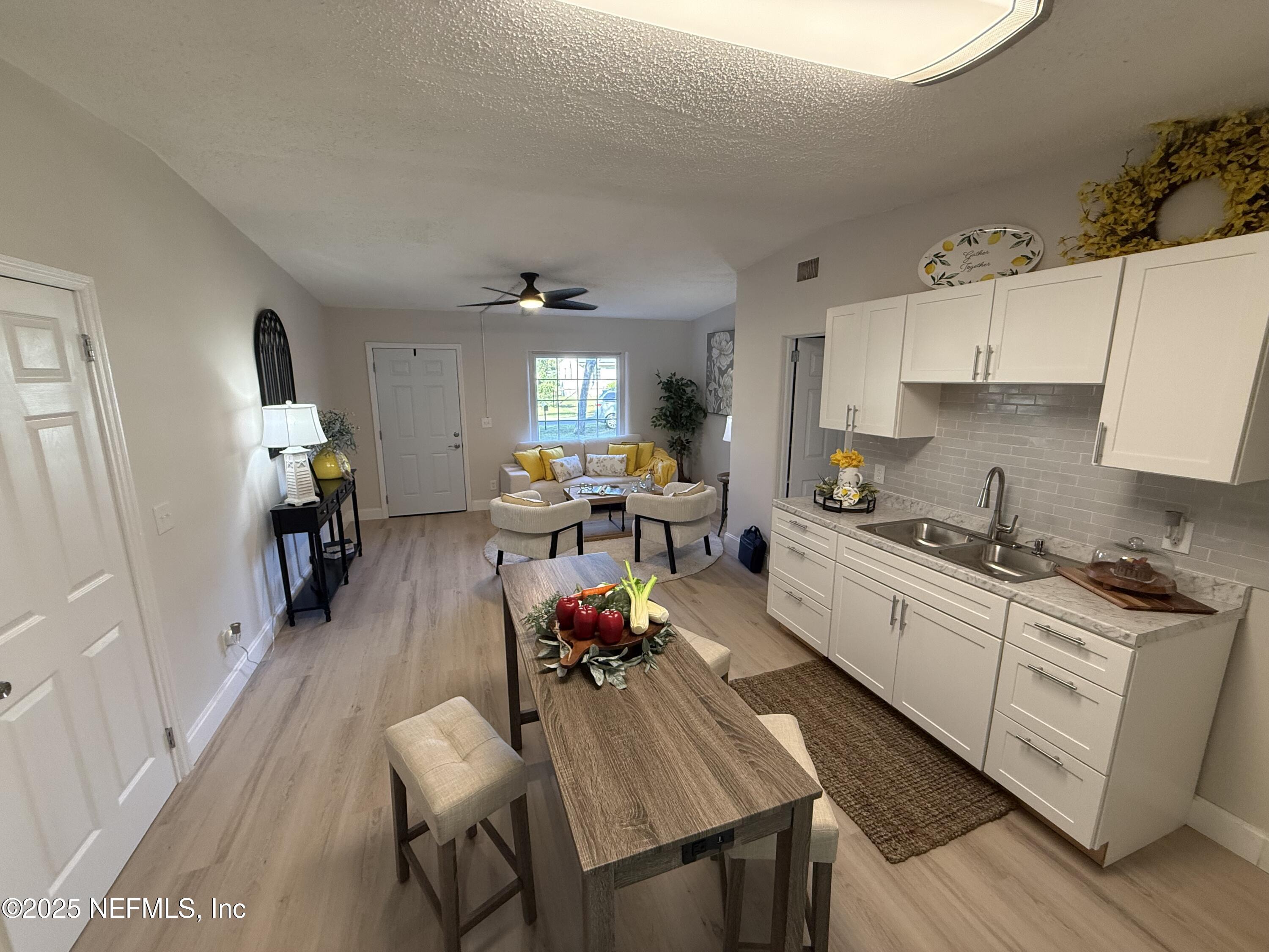 10563 Arendal Road Jacksonville, FL 32218 - Photo 4 of 11 a kitchen with a dining table wooden floor and stainless steel appliances