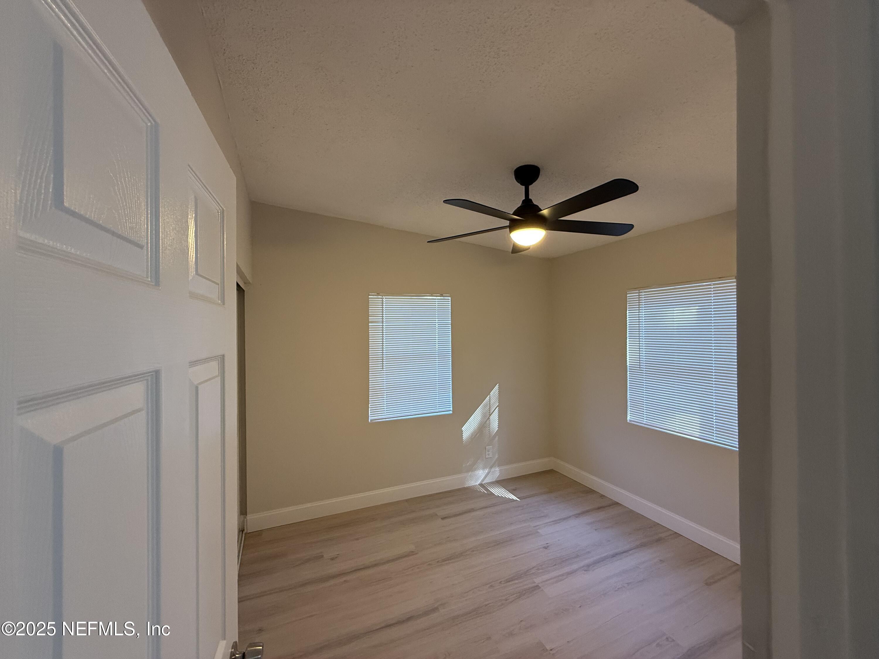 10563 Arendal Road Jacksonville, FL 32218 - Photo 5 of 11 a view of empty room with wooden floor and fan