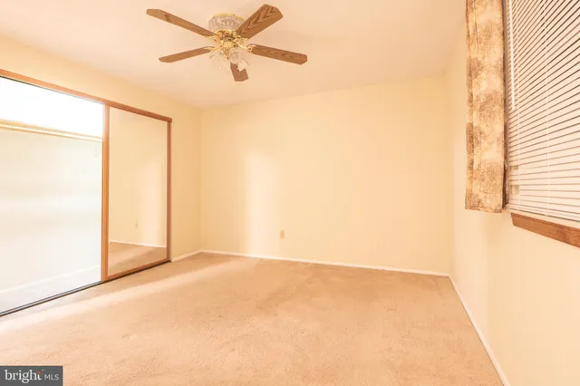 an empty room with a window and a fan