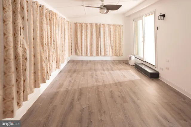 a view of a room with wooden floor and fan