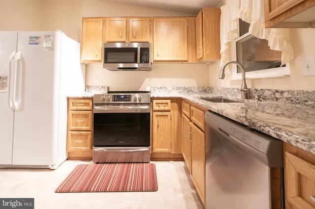 a kitchen with a stove top oven a sink and a microwave