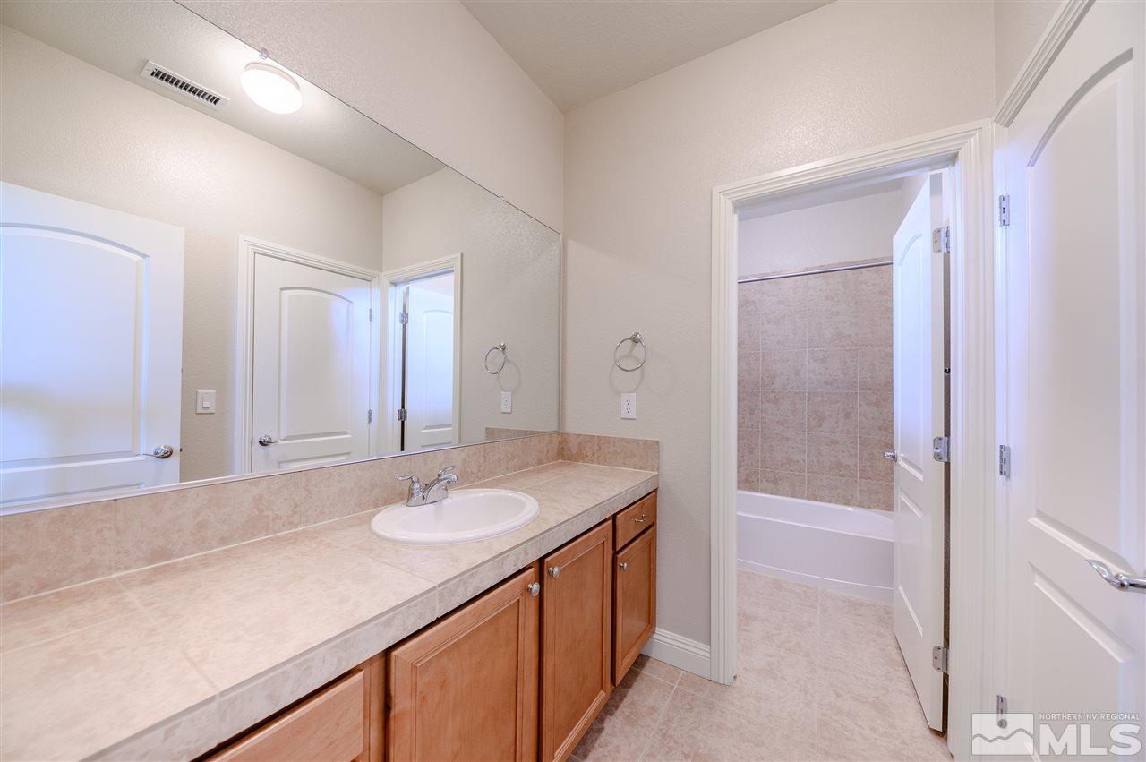 9880 Kerrydale Court Reno, NV 89521 - Photo 8 of 20 a bathroom with a sink a mirror and a bathtub