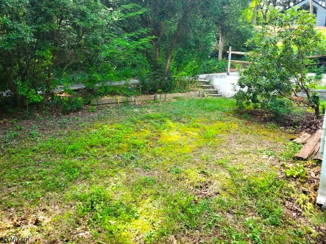 a view of a backyard with table and chairs and wooden fence