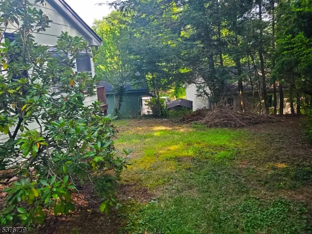 a view of a backyard with table and chairs and a large tree