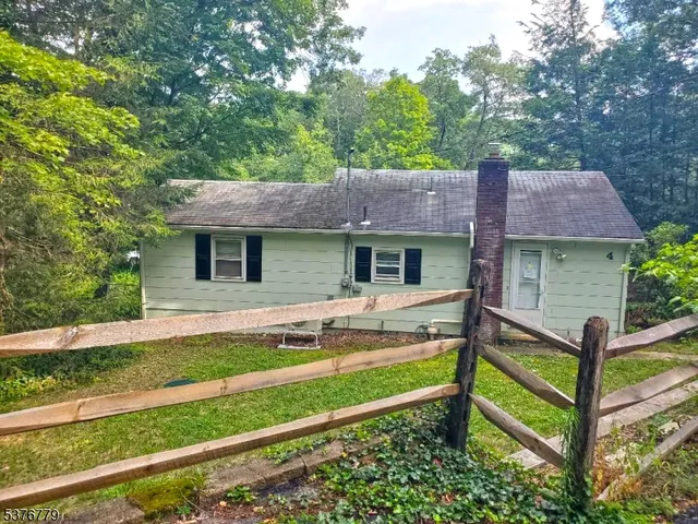a view of house with backyard and outdoor seating