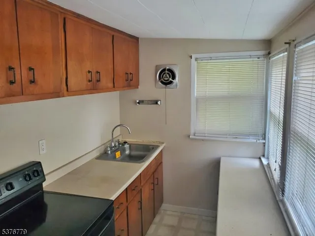 a kitchen with a sink a stove and cabinets