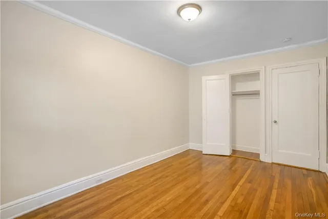 an empty room with wooden floor and closet