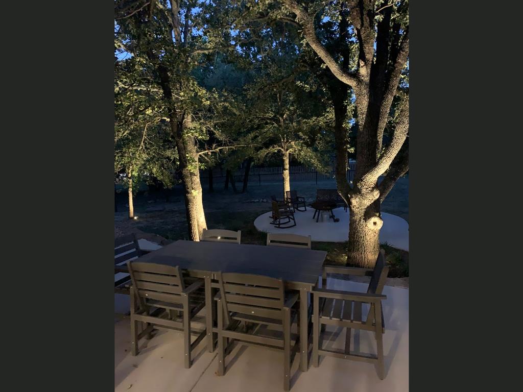 149 Overton Ridge Circle Weatherford, TX 76088 - Photo 38 of 39 Patio area with concrete surfacing, surrounded by mature trees, and featuring integrated landscape lighting