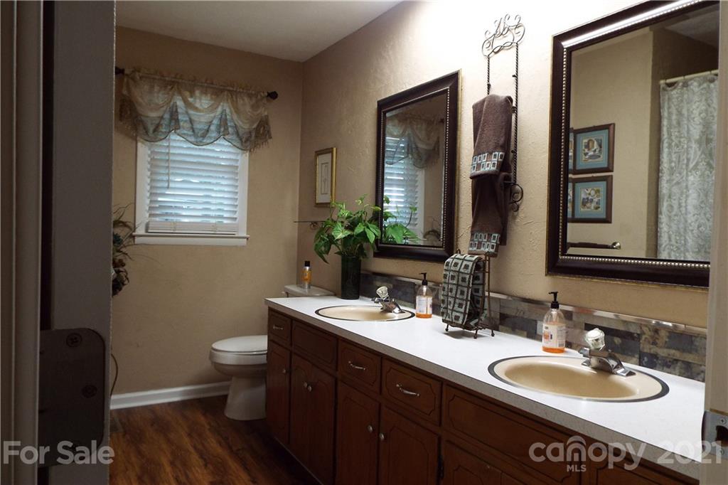 7905 Barkley Road Sherrills Ford, NC 28673 - Photo 17 of 31 a bathroom with a double vanity sink toilet mirror and a window