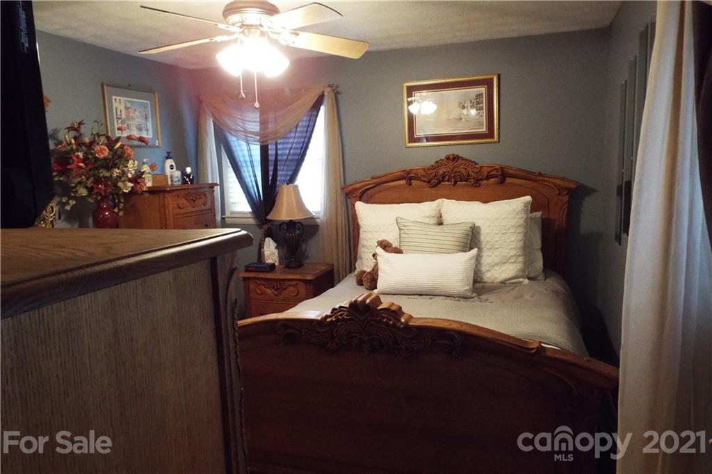 7905 Barkley Road Sherrills Ford, NC 28673 - Photo 21 of 31 a bedroom with a bed and a chandelier