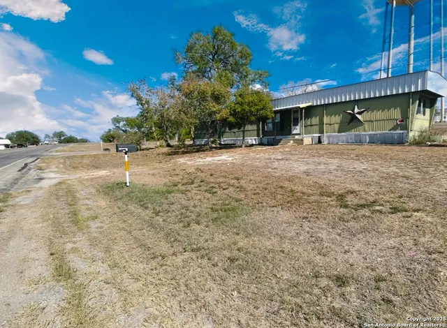 a view of an house with backyard and bushes