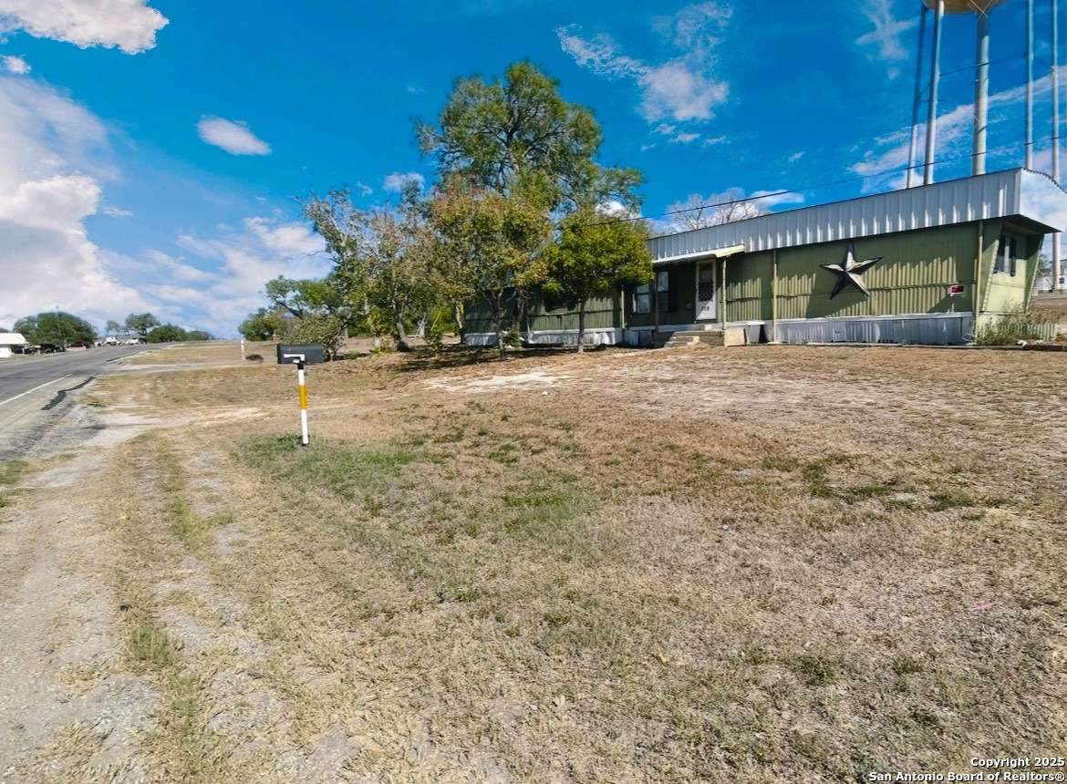 a view of an house with backyard and bushes