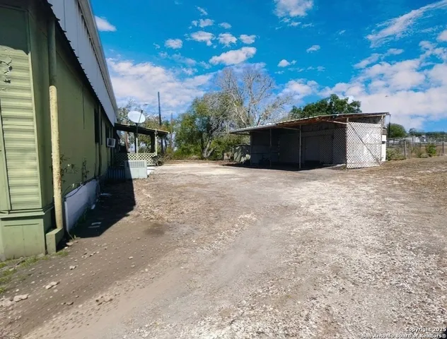 a backyard of a house with lots of green space and wooden fence