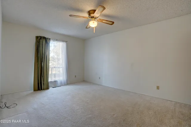 a view of an empty room with closet and refrigerator