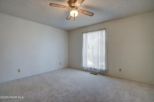 a view of empty room with ceiling fan