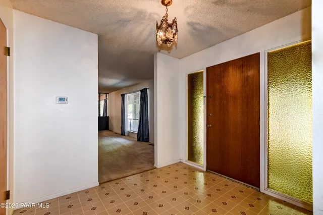 a view of hallway with chandelier and front door
