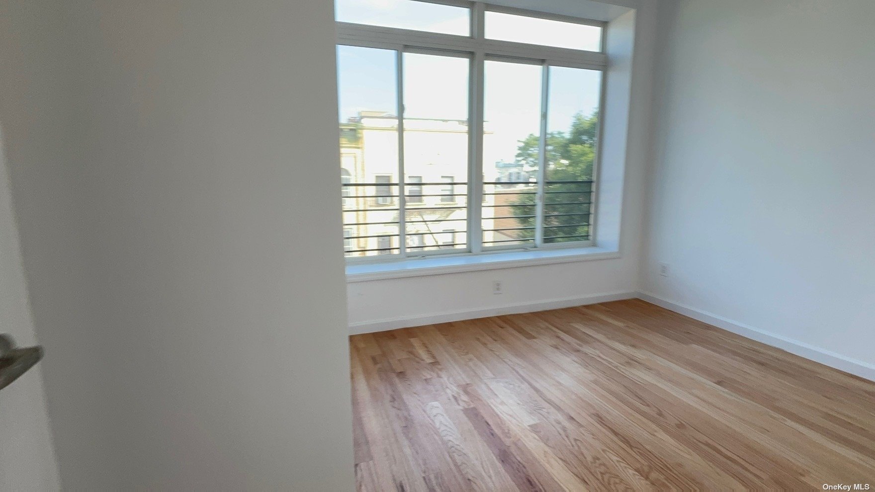 1821 Grove Street Queens, NY 11385 - Photo 15 of 30 a view of an empty room with wooden floor and a window