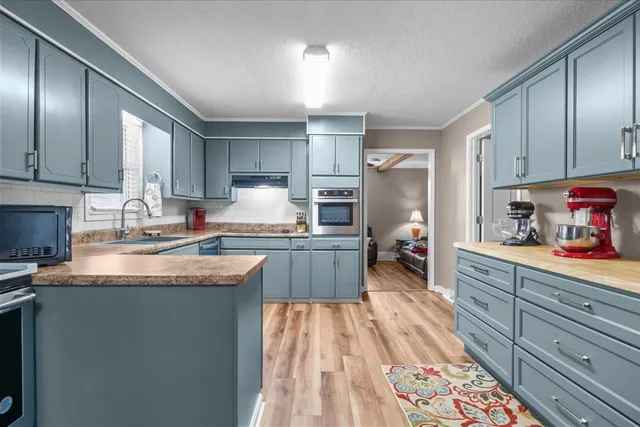 a kitchen with granite countertop a sink stove and cabinets