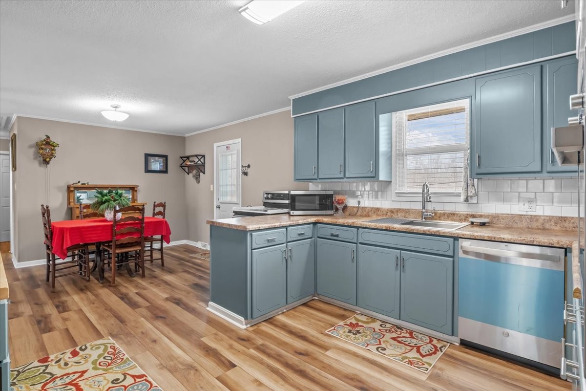 140 Mockingbird Street Erin, TN 37061 - Photo 11 of 36 a kitchen that has a sink cabinets and wooden floor
