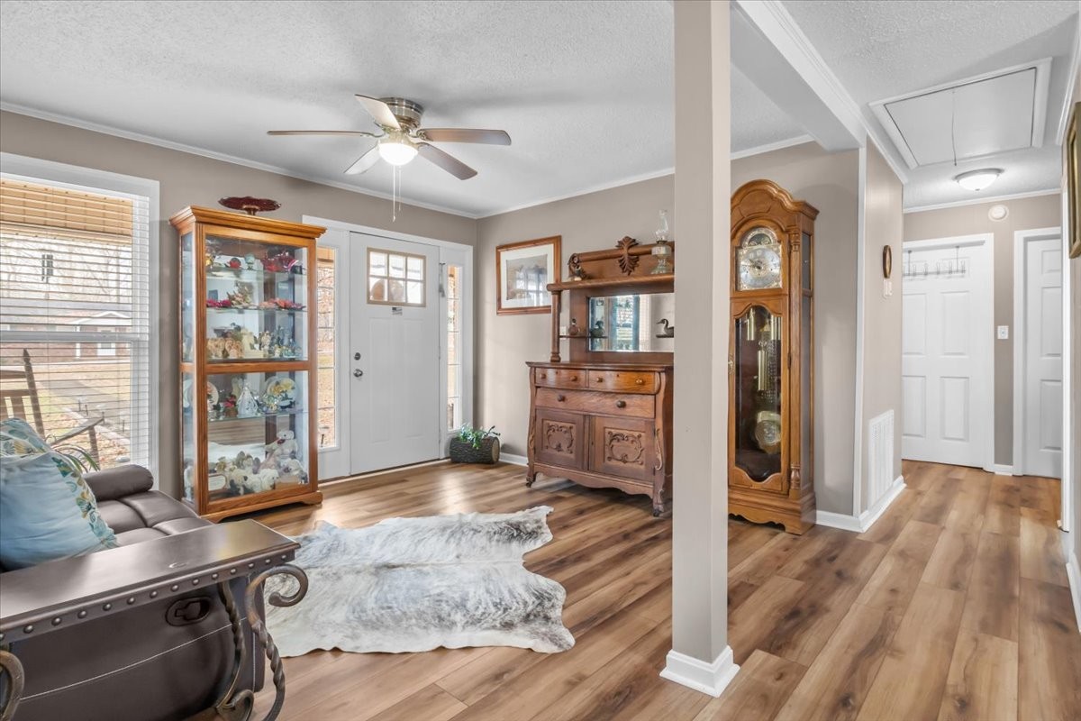 140 Mockingbird Street Erin, TN 37061 - Photo 10 of 36 a view of a livingroom with wooden floor and a ceiling fan