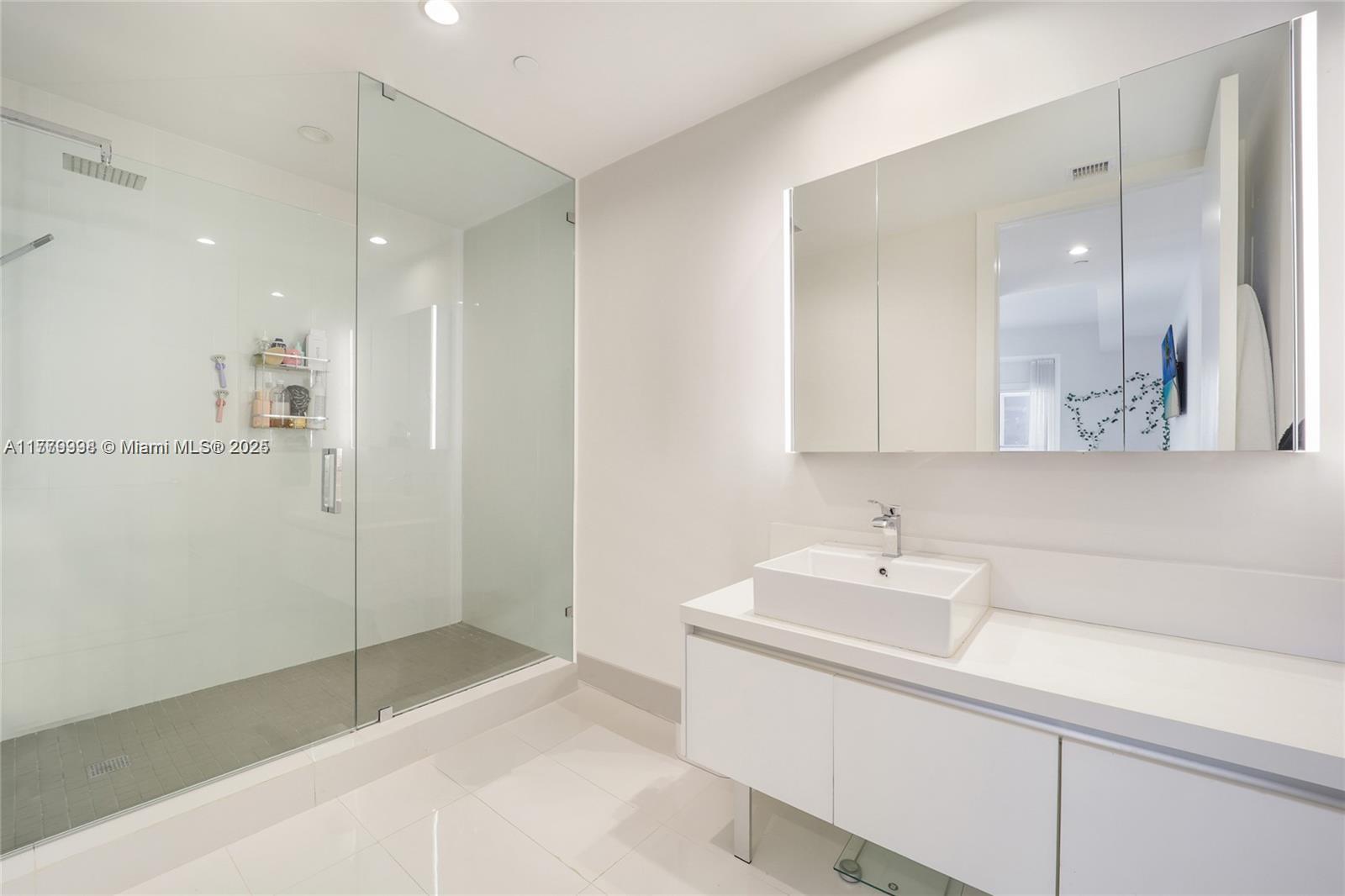 1100 Biscayne Boulevard, Unit 3004 Miami, FL 33132 - Photo 11 of 15 a bathroom with a sink and a mirror