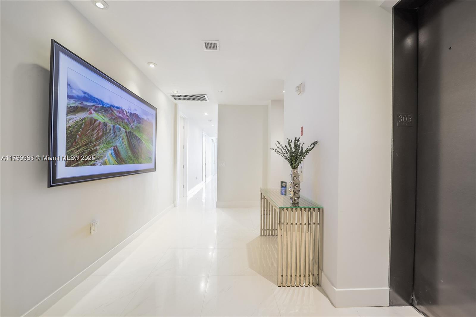 1100 Biscayne Boulevard, Unit 3004 Miami, FL 33132 - Photo 2 of 15 a view of a hallway with wooden floor and a cabinet