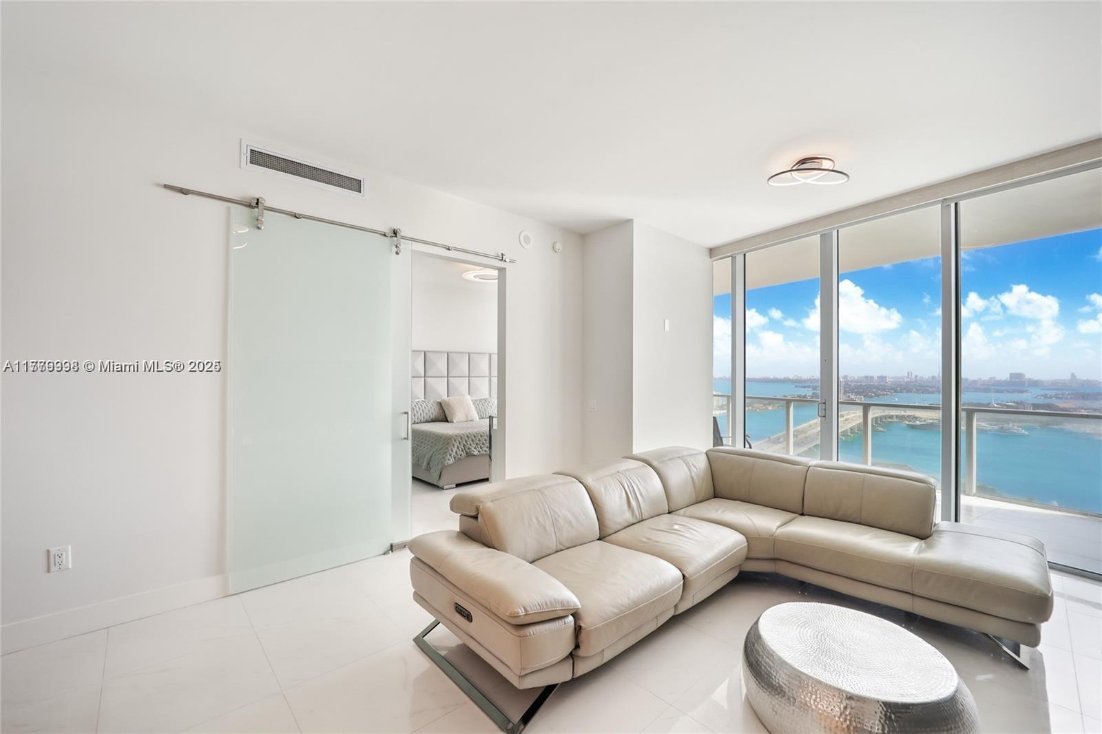 1100 Biscayne Boulevard, Unit 3004 Miami, FL 33132 - Photo 6 of 15 a living room with furniture and a large window