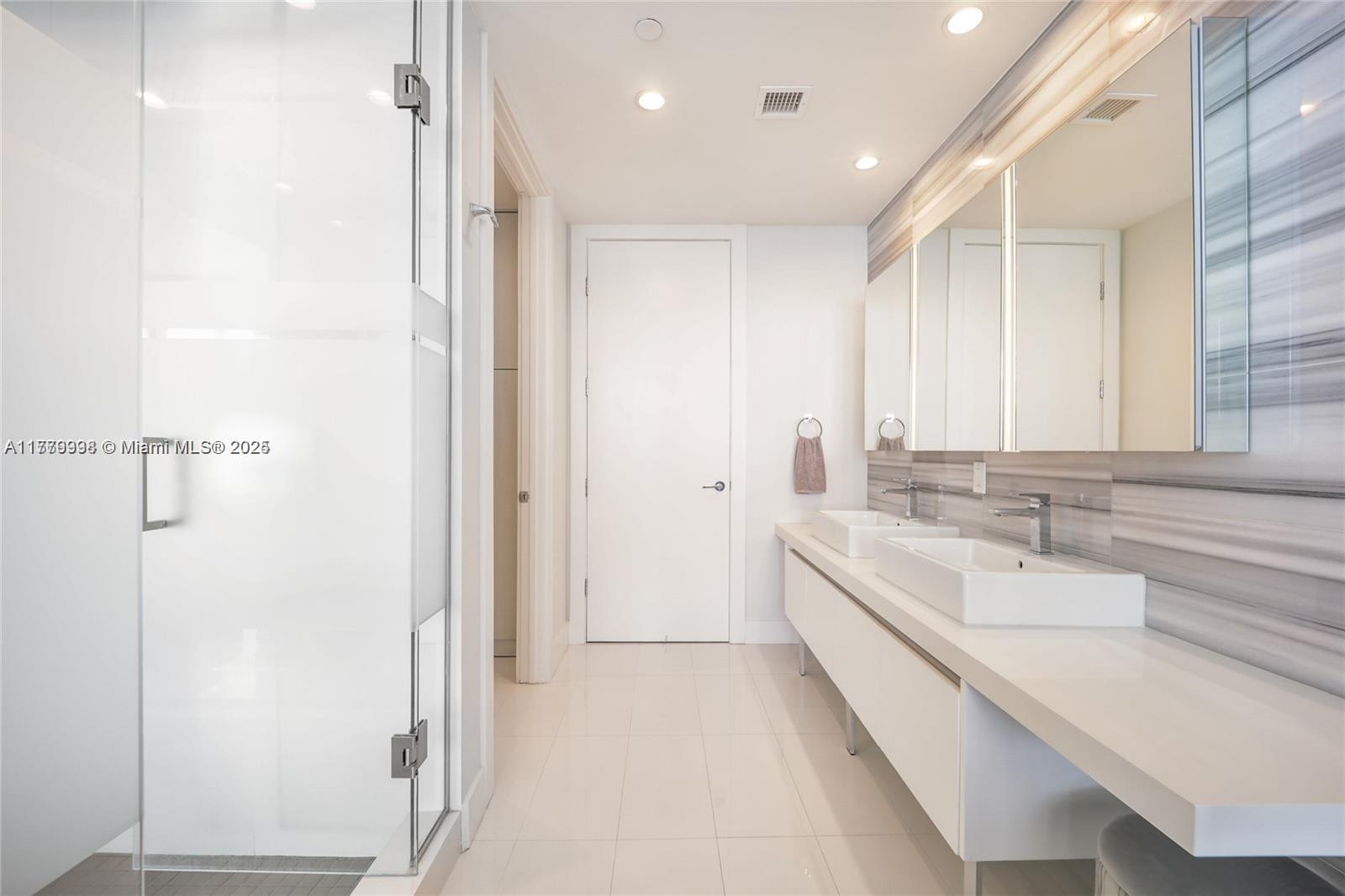 1100 Biscayne Boulevard, Unit 3004 Miami, FL 33132 - Photo 8 of 15 a bathroom with a double vanity sink and mirror with shower