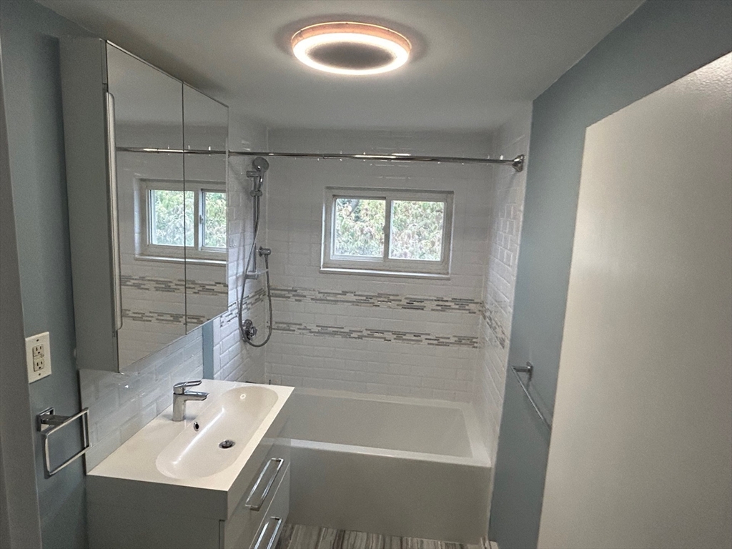 37 Will Drive, Unit 12 Canton, MA 02021 - Photo 14 of 20 a bathroom with a tub sink vanity granite and a window