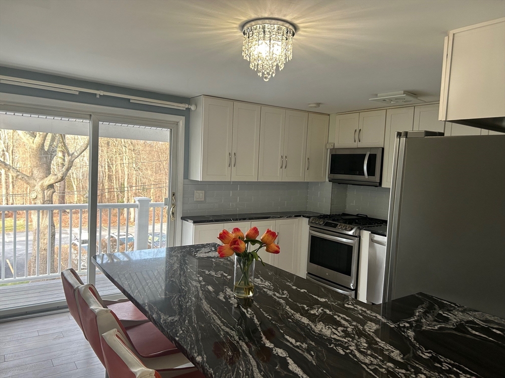 37 Will Drive, Unit 12 Canton, MA 02021 - Photo 3 of 20 a kitchen with stainless steel appliances a stove sink microwave and refrigerator