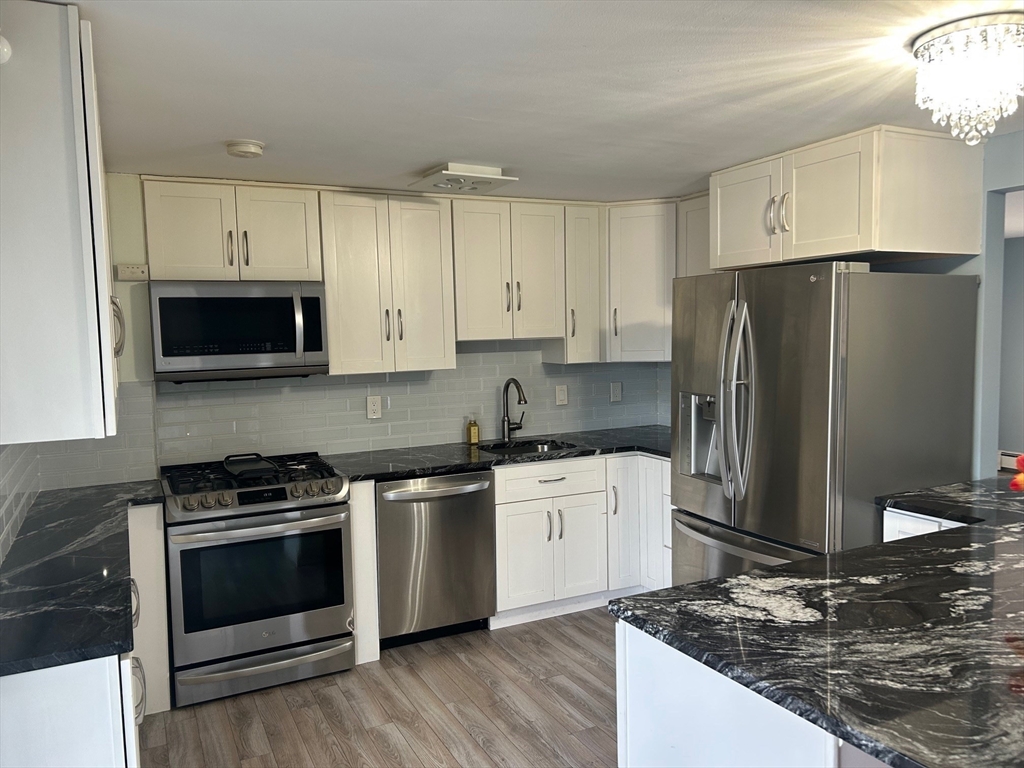 37 Will Drive, Unit 12 Canton, MA 02021 - Photo 4 of 20 a kitchen with stainless steel appliances a stove a sink and a refrigerator