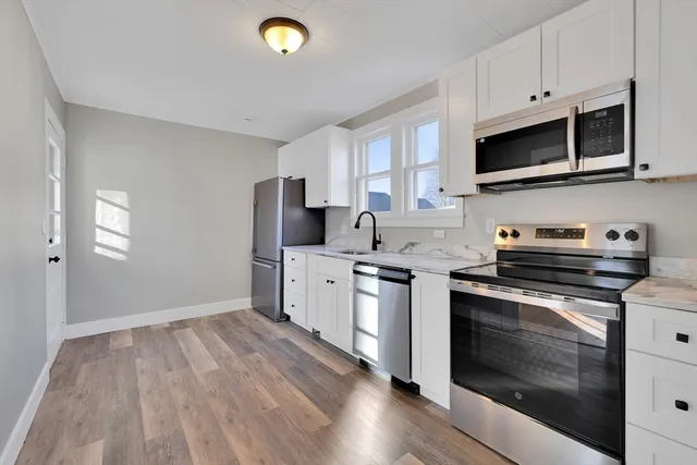 a kitchen with stainless steel appliances a stove a sink and a microwave