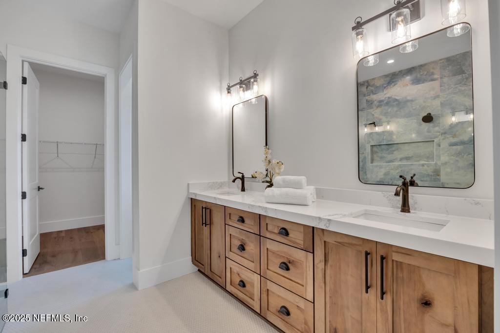 8515 Florence Cove Road St. Augustine, FL 32092 - Photo 12 of 16 a bathroom with a double vanity sink a mirror and shower